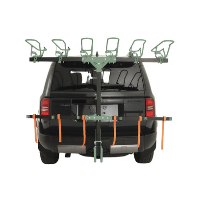 Car roof rack system on a black SUV with green crossbars and orange straps.