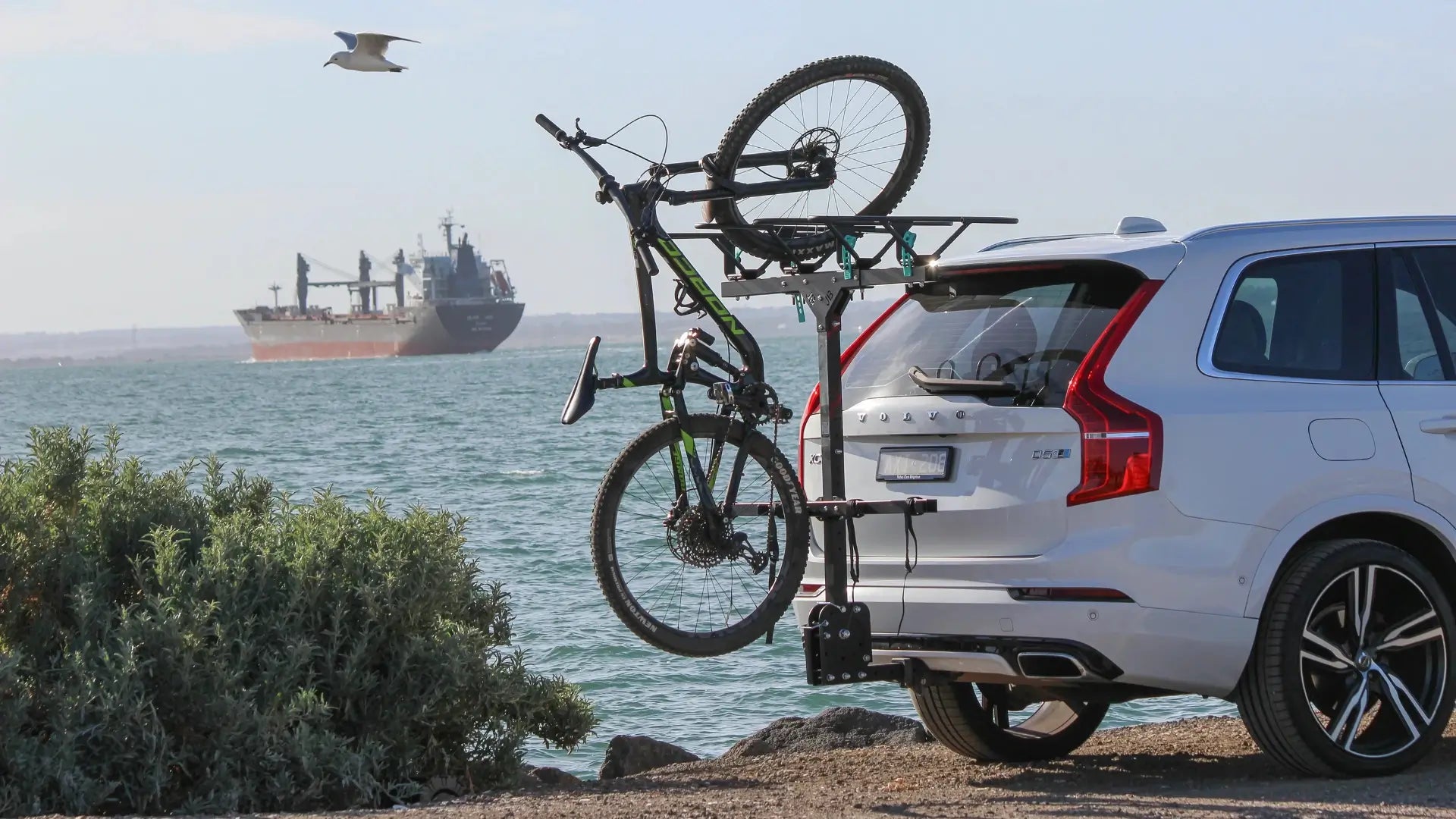 White SUV with JB Racks and bike, tanker vessel on the background